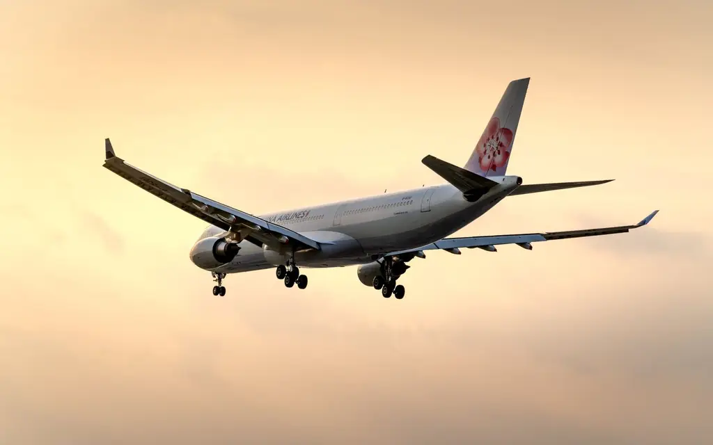A passenger jet flies through a beautiful golden sky, showcasing aviation and travel against a stunning sunset backdrop.